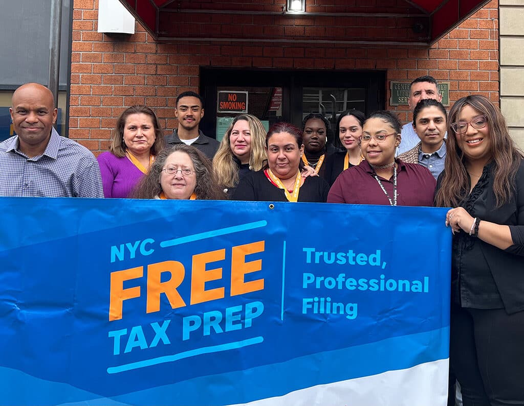 New York City tax team hold "free tax prep" sign.