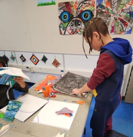 A student using stencils to cut out pieces of the class quilt